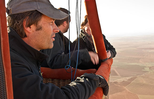 Pilot Michel Ries on board of a Maroc Montgolfière hot air balloon with Marrakech desert view