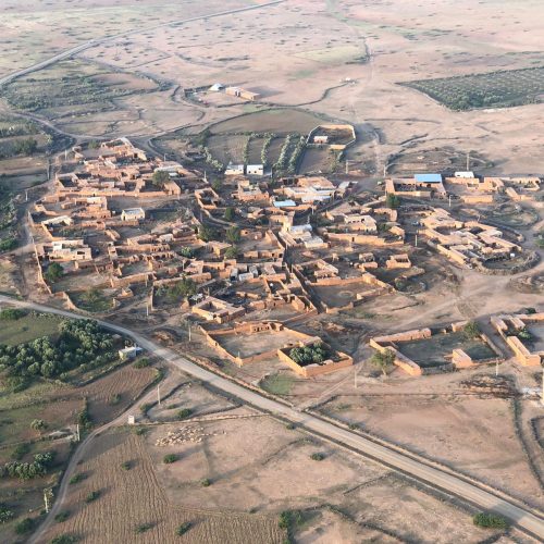 A Marrakech Hot Air Balloon flying over a typical village